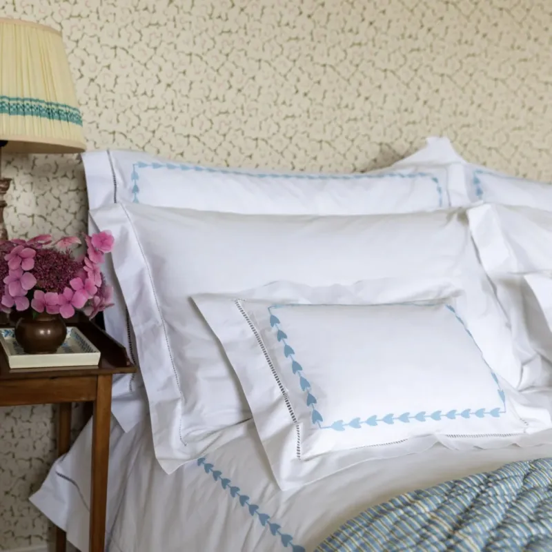 A pretty cotton duvet cover featuring a hand hemstitched border and embroidered blue leaves