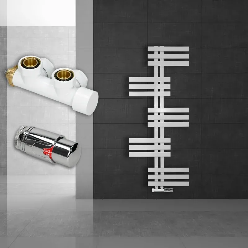 Weißer Heizkörper an einer dunklen Wand mit zwei Armaturen.