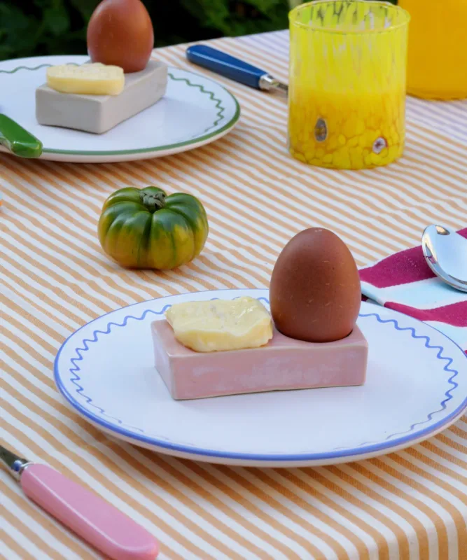Handmade rectangular stoneware egg cup in a pink finish. Artisanal design with a minimalist aesthetic, perfect for serving soft-boiled eggs. Unique handcrafted texture and earthy tone, ideal for rustic or modern kitchen décor.
